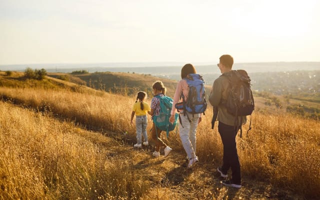 A family hiking on a trail on a sunny autumn day