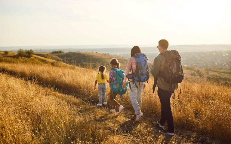 A family hiking on a trail on a sunny autumn day